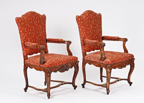 A pair of French 19th century walnut fauteuils with shaped backs and open arms on carved cabriole supports, united by shaped stretcher, 68cm wide x...