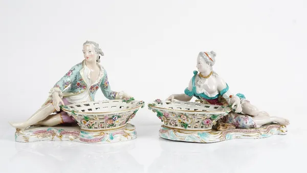 A matched pair of Meissen sweetmeat dishes, late 19th century, probably outside decorated, modelled as a reclining young man and woman holding a...