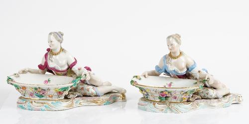 Two similar Meissen porcelain outside decorated sweetmeat dishes, late 19th century, each modelled as a reclining young woman holding a basket...