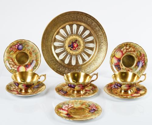 An Aynsley plate, centrally printed and painted with fruit reserved against a foliate gilt ground, 26.5cm diameter;  and three similar Aynsley fruit...