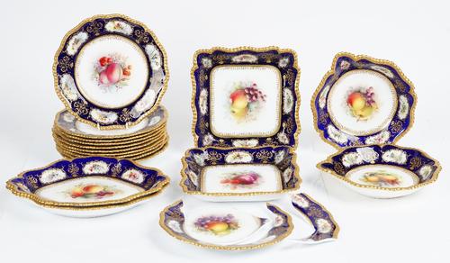 A Royal Worcester part dessert service, circa 1915, each piece painted with an arrangement of fruit, signed Cole, inside a cobalt blue border...