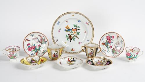 Two Dresden quatrelobed cups and saucers, late 19th century, painted with panels of courting couples and flowers against a yellow or black ground,...