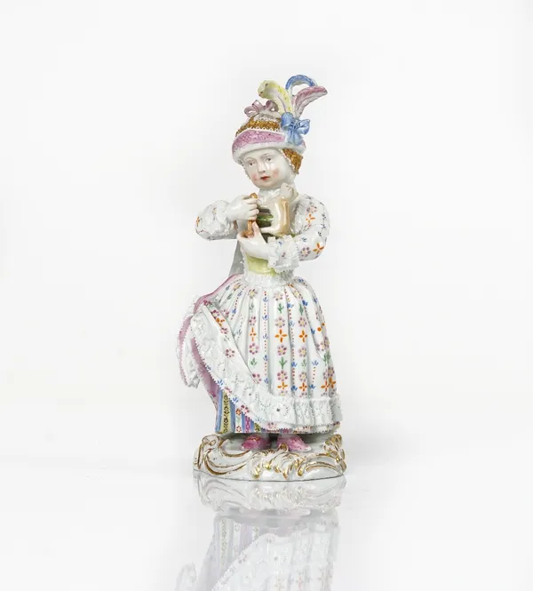 A Meissen figure of a girl holding a toy animal, late 19th century, modelled standing in a long dress and wearing a plumed cap, blue crossed swords...