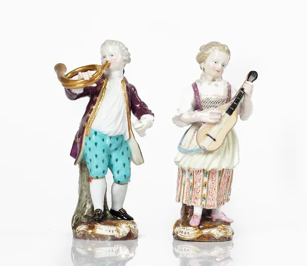 A pair of Meissen figures of musicians, late 19th century, modelled as a boy playing a French horn and a girl playing the lute, blue crossed swords...