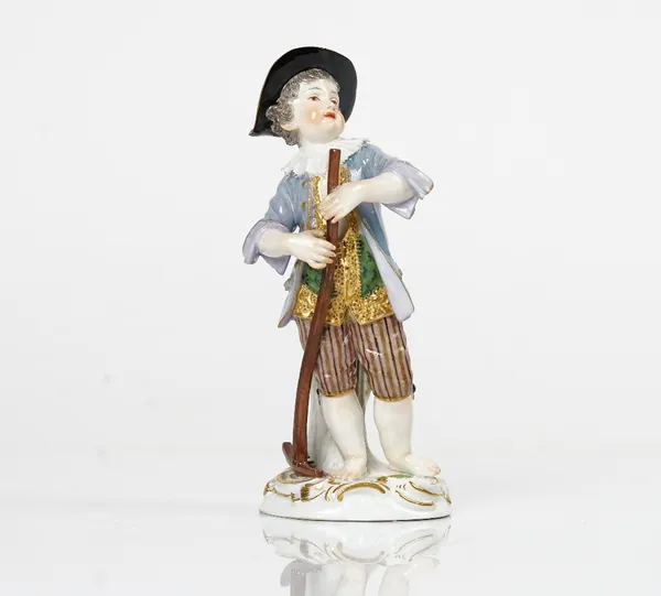 A Meissen figure of a boy gardener, circa 1900, modelled standing standing before a tree stump holding a rake, blue crossed swords mark, incised 10,...