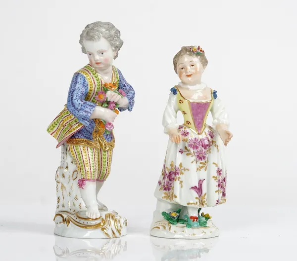 A Meissen figure of a boy, 19th century, standing before a tree stump holding a bunch of flowers, blue crossed swords mark, impressed 59, 14cm. high;...