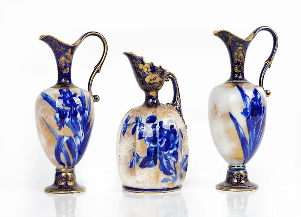 A pair of Doulton Burslem earthenware ewers, circa 1900, decorated with blue irises against a speckled gilt ground, brown printed and impressed...