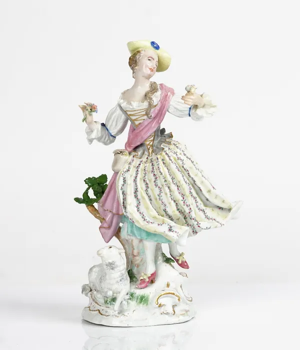 A Meissen figure of a shepherdess, circa 1770, modelled standing before a tree stump in dancing pose holding a flower posy in each hand, a recumbent...