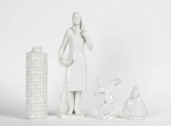 Four items of Meissen white glazed porcelain, 20th century, comprising; a figure of a woman carrying a bowl, 34cm. high; a small figure of a woman in...