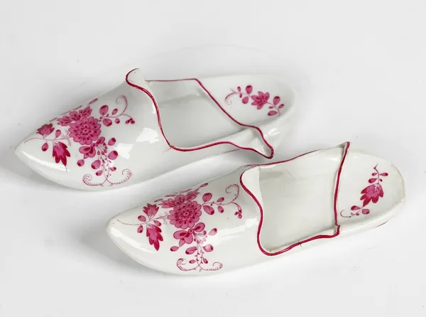 Two similar Meissen outside decorated slippers, late 19th century, each painted in puce camaieu with flowers, blue cancelled crossed swords marks,...