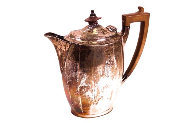 A silver hot water jug, of panelled oval form, with wooden fittings, Sheffield 1928, gross weight 438 gms.