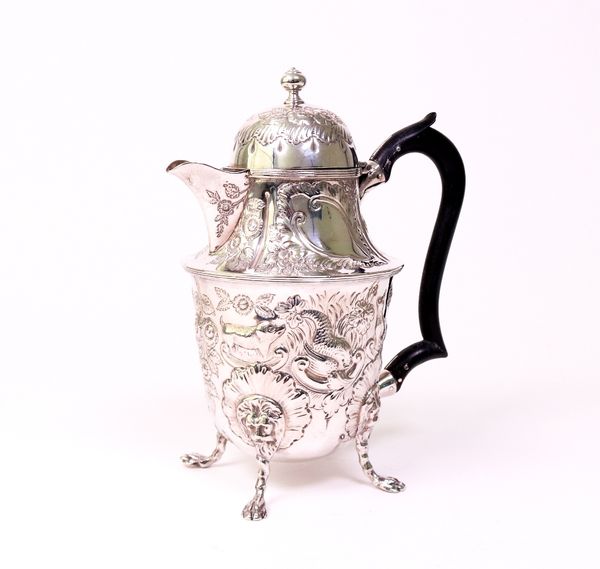 A silver hot water jug, the body decorated with animals, floral sprays and foliate scrolls, raised on four pad feet, fitted with a wooden handle,...
