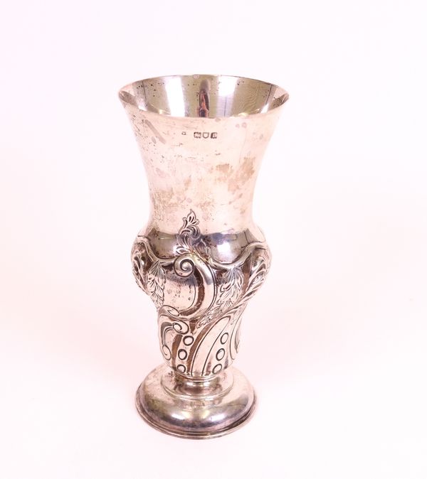 A silver vase, the body embossed with spiral fluting and foliate sprays, raised on a circular foot, London 1904, height 20.5cm, weight 265 gms.