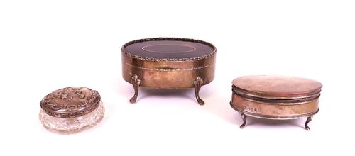 A silver and tortoiseshell oval hinge lidded trinket box, raised on four feet, Birmingham 1918, a silver oval hinge lidded trinket box, raised on...
