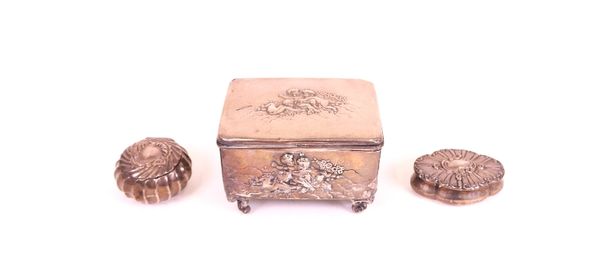 Silver, comprising; a rectangular hinge lidded trinket box, the lid and the sides embossed with putto amidst flowers and raised on four scroll...