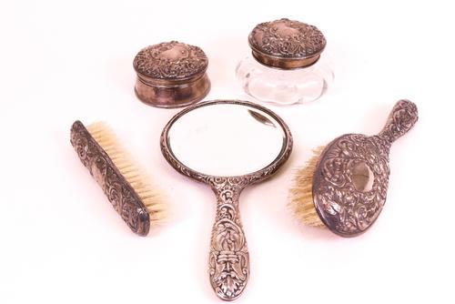A group of silver mounted dressing table wares, comprising; a glass powder bowl, fitted with a mirror to the lid, a hinge lidded circular trinket...