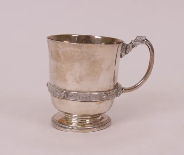 A silver christening mug, decorated with a Celtic style band and handle, raised on a circular foot, height 8.3cm, Birmingham 1932, by Mappin & Webb...
