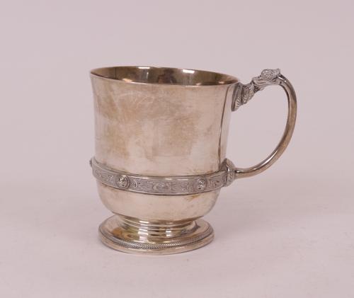 A silver christening mug, decorated with a Celtic style band and handle, raised on a circular foot, height 8.3cm, Birmingham 1932, by Mappin & Webb...