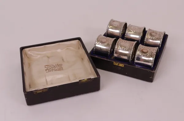 A set of six napkin rings, numbered from one to six within wreath shaped surrounds, all Birmingham 1913, combined weight 123 gms, with a case.