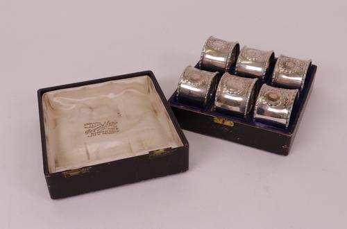 A set of six napkin rings, numbered from one to six within wreath shaped surrounds, all Birmingham 1913, combined weight 123 gms, with a case.