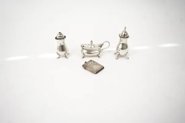 A silver vesta case and three silver condiments, (4).