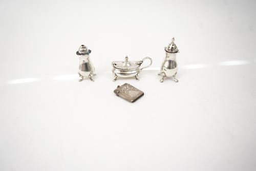 A silver vesta case and three silver condiments, (4).