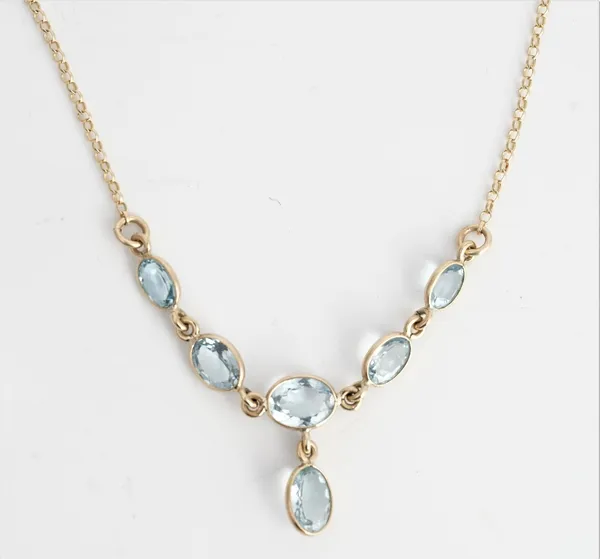 A gold and aquamarine necklace, the front collet set with a row of five graduated oval cut aquamarines and with a single aquamarine drop, on a...