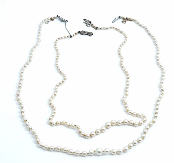 A single row necklace of graduated cultured pearls, on a diamond set clasp, designed as a bow, length including clasp 50.5cm and another single row...