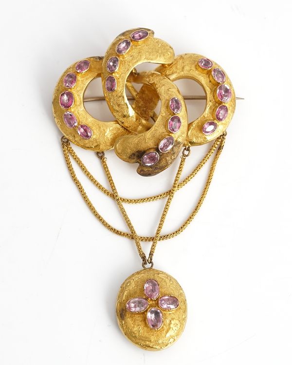 A Victorian foil backed pink gemstone set brooch, of four section entwined design, the front with an oval pendant locket, glazed at the back...