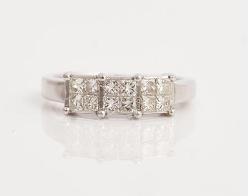 An 18ct white gold and diamond ring, designed as a row of three four stone square clusters, each mounted with four princess cut diamonds, ring size H...
