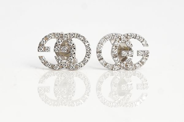 A Gucci pair of white gold and diamond earstuds, each designed as GG, mounted with circular cut diamonds, the backs with post and butterfly clip...