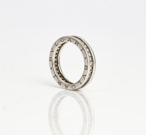 A Bvlgari white gold and diamond full eternity ring, mounted with circular cut diamonds, the sides of the band detailed Bvlgari twice, ring size L,...