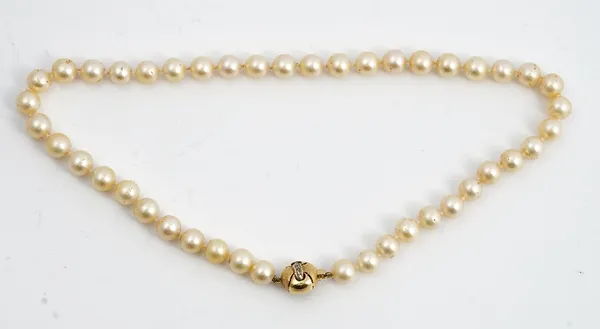 A single strand uniform cultured pearl necklace, suspended from a white stone set yellow precious metal bead clasp.