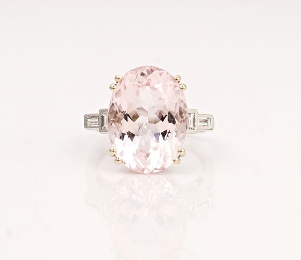 An 18ct white gold, morganite and diamond ring, claw set with the oval cut morganite between baguette diamond two stone shoulders, with two...