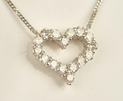 A white gold and diamond set pendant necklace, in an open heart shaped design, mounted with circular cut diamonds on a white gold neckchain,