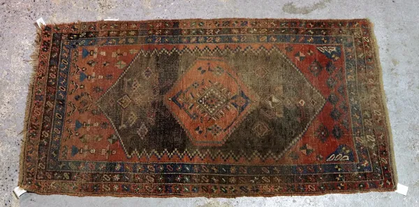 A North Western Persian rug, madder and brown field, six figures, 240cm x 132cm