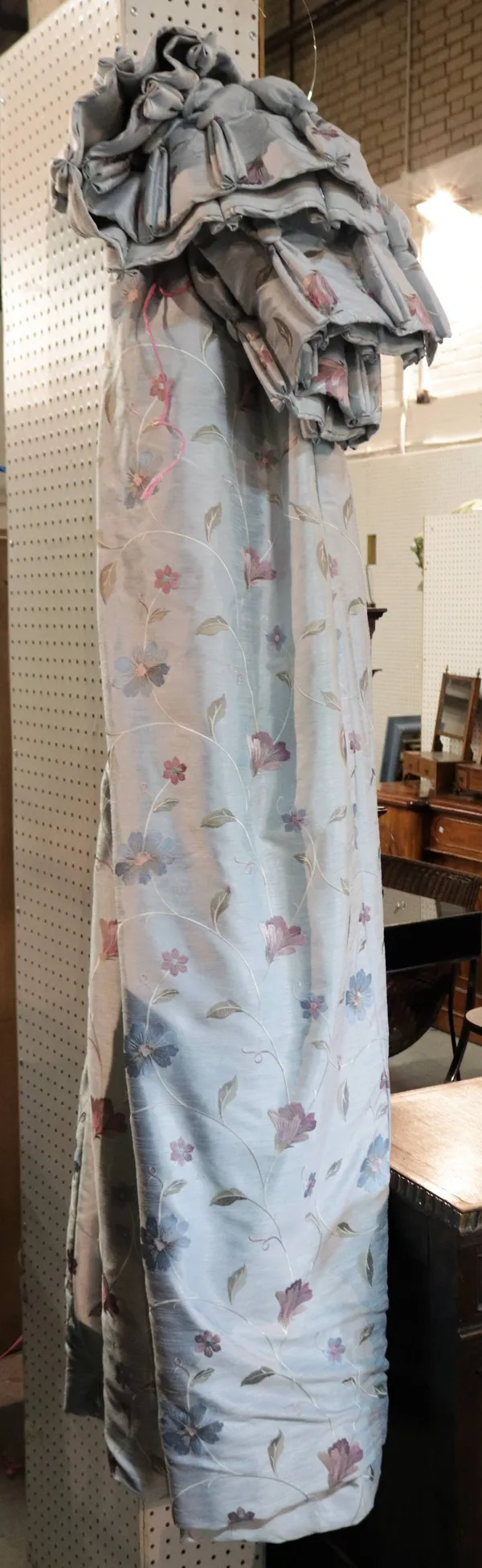 A pair of blue lined and interlined curtains with embroided flower decoration
