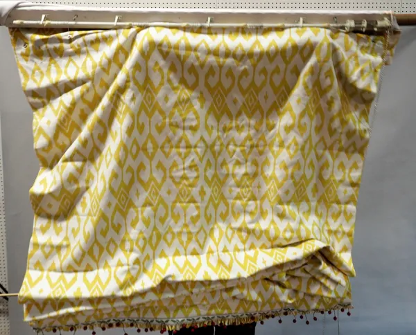 A set of three matching Roman blinds, with a repeated yellow design, on a white ground,