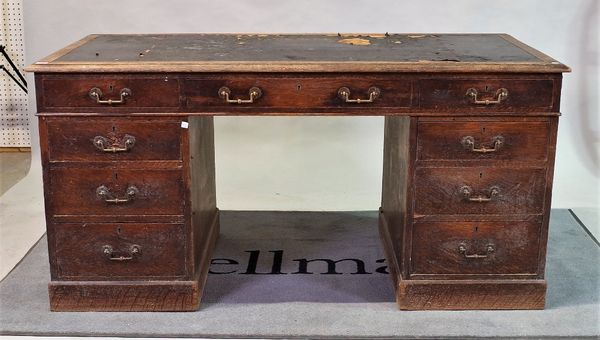 A late 19th century oak pedestal desk with inset leather top over nine drawers about the knee.