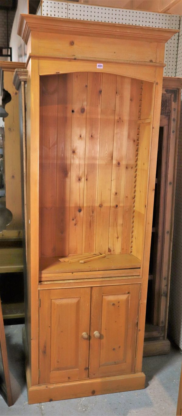 A modern pine three-tier open bookcase with cupboard base