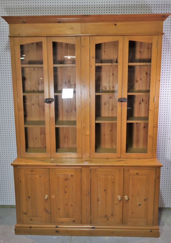 A modern pine floor standing display cabinet with four glazed doors over four door cupboard base.