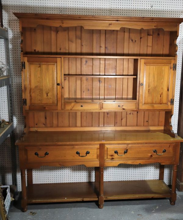 A modern pine kitchen dresser with plate rack flanked by cupboard doors over two short drawers