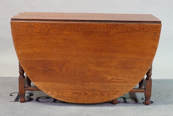 A 17th century style oak gateleg dining table on turned supports