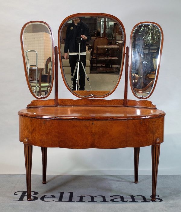 An early 20th century walnut oval dressing table with tryptich mirror back