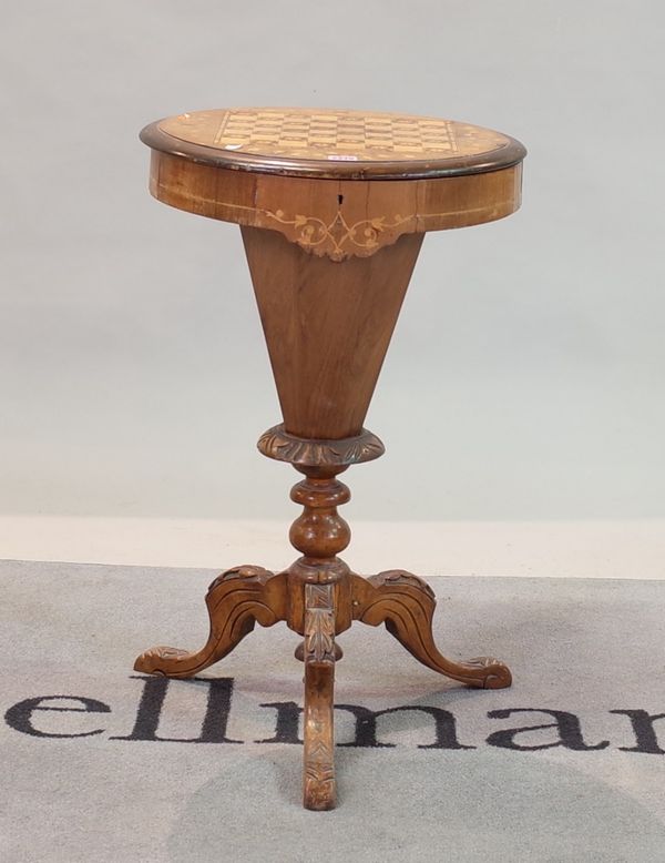 A Victorian walnut sewing table with tapering column on three downswept supports