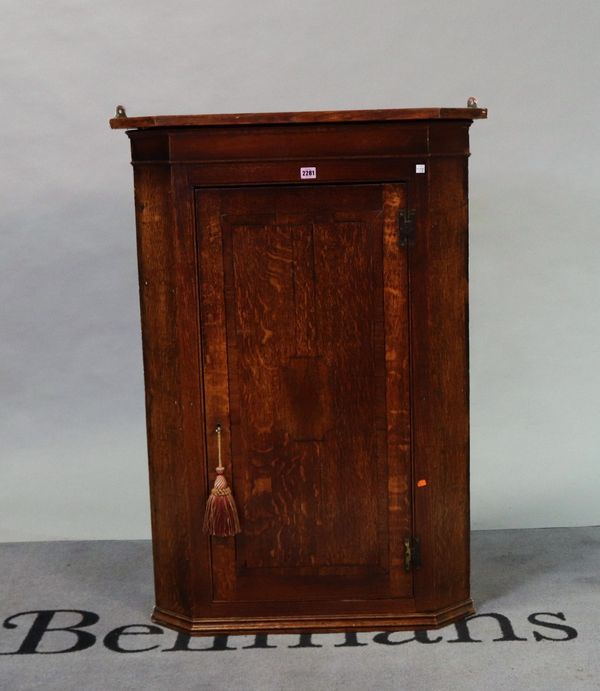 A late 19th century oak hanging corner cupboard