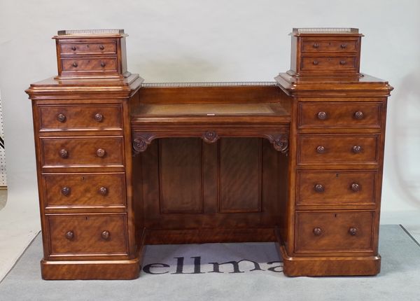 A Victorian mahogany writing desk with inset leather top flanked by eight graduated drawers on a plinth base,