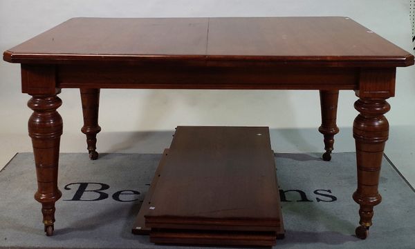 A late Victorian oak extending dining table on tapering turned supports with three extra leaves