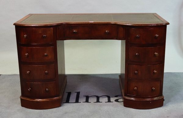 A 19th century mahogany writing desk with tooled leather top over nine drawers