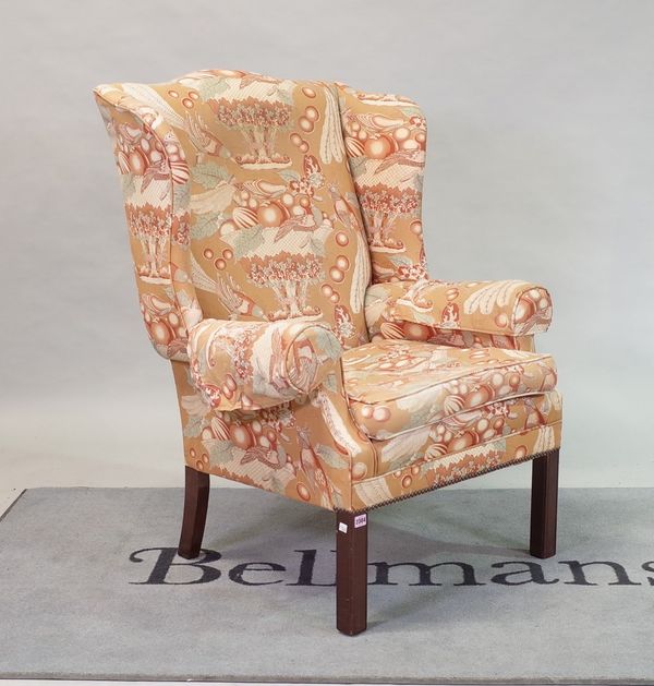 An 18th century style wingback easy armchair, on block supports